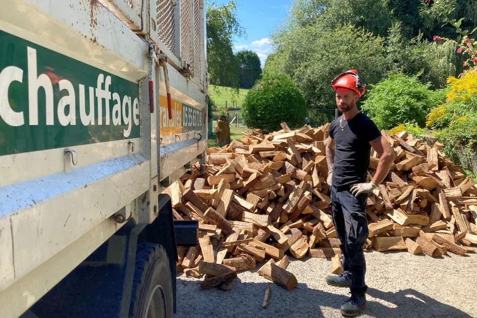 Bûches fendues empilées devant le camion de livraison